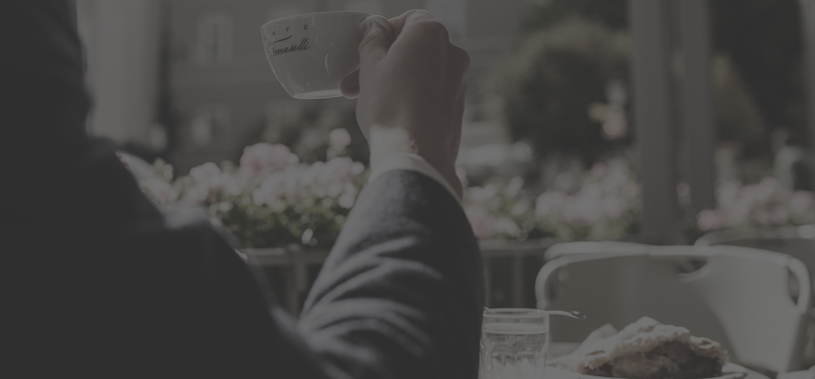 Eine Tasse Caffe wird vom Tisch gehoben